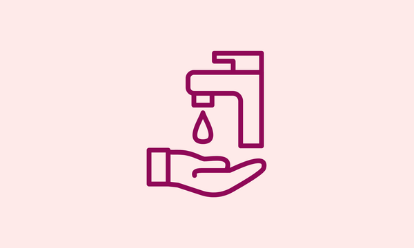 A hand holding a faucet with a drop of water coming out of it